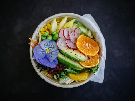 A bowl filled with fruit and vegetables on top of a table